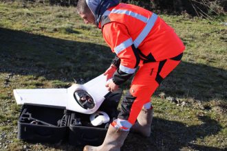 Technicien géomètre sortant une aile volante de sa valise de protection