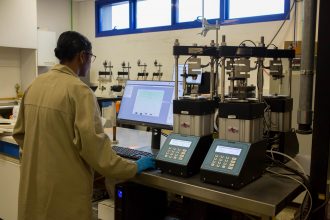 Technicien réalisant un essai triaxial au laboratoire mécanique des sols/géotechnique du Laboratoire CBTP