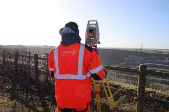 Technicien derrière un théodolite en carrière