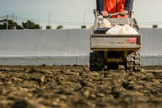 Technicien utilisant une brouette motorisée à chenille dans un centre d'enfouissement