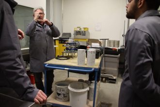 Un chef de laboratoire du secteur béton explique les préparatifs nécessaires sur un éprouvette béton avant un essai de résistance à la compression