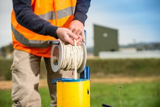 Technicien réalisant une mesure de niveau de nappe avec une sonde piézométrique